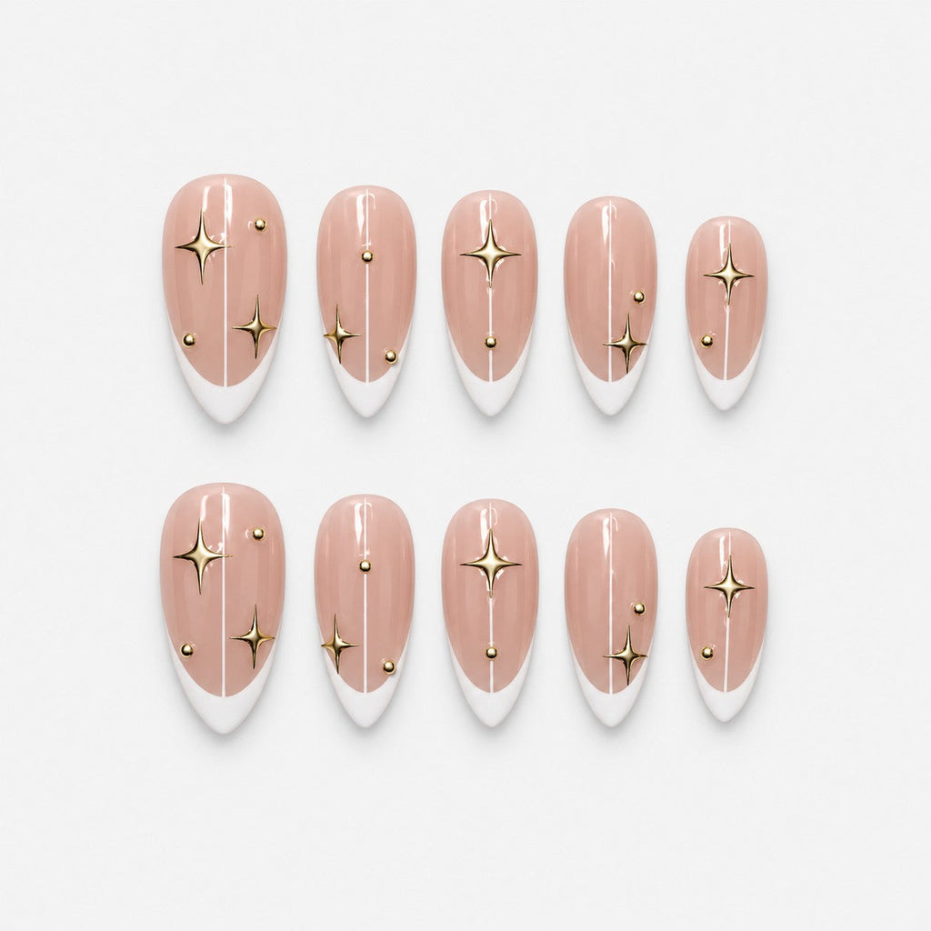catalog: Medium almond press-on nails with white French tips on a sheer pink base, gold star decals, thin gold lines and small gold studs.