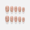catalog: Medium almond press-on nails with white French tips on a sheer pink base, gold star decals, thin gold lines and small gold studs.