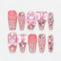 catalog: Long square press-on nails in sheer pink glitter with sculpted teddy bear charms, iridescent bows, glass hearts and small rhinestones.