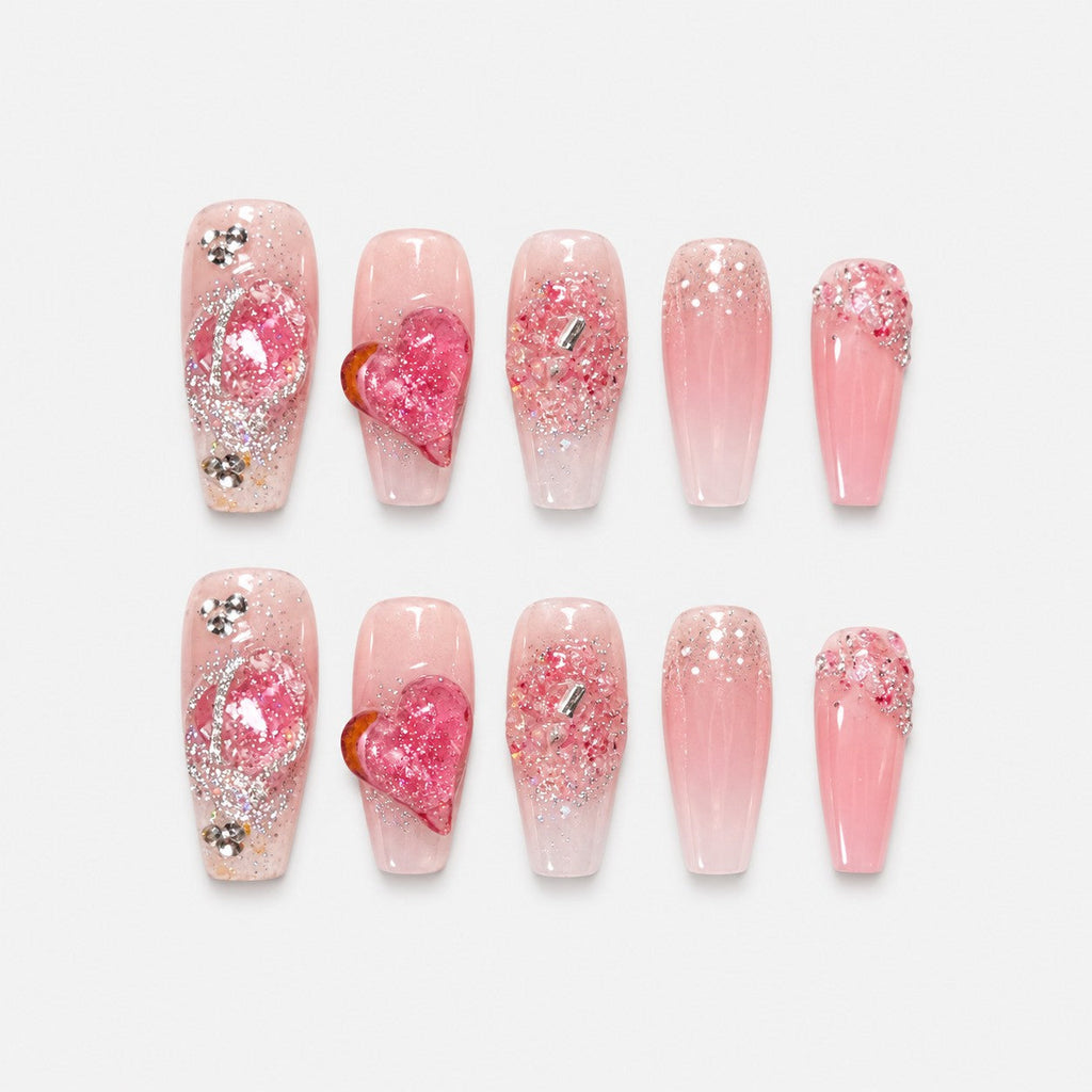 catalog: Long coffin press-on nails in sheer pink with a raised glitter heart, silver beading and crystal grit at the cuticle.