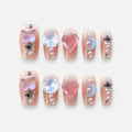 catalog: Medium coffin press-on nails in sheer pink with cuticle glitter and charms including a heart, opal stone, butterfly, blue crescent, chrome stars and pearls.