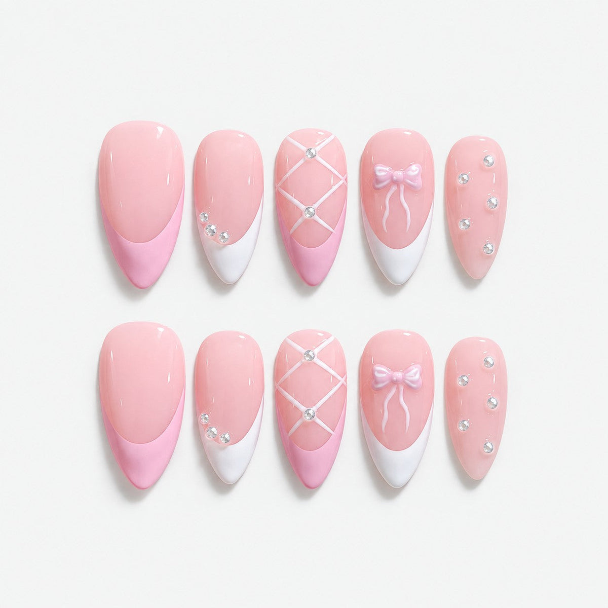 catalog: Medium almond press-on nails in pale baby pink with white French tips, a lattice nail, a pale bow and scattered clear crystals.