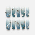 catalog: Medium coffin press-on nails in blue to white gradient with silver glitter, sculpted white waves and clear rhinestone clusters.