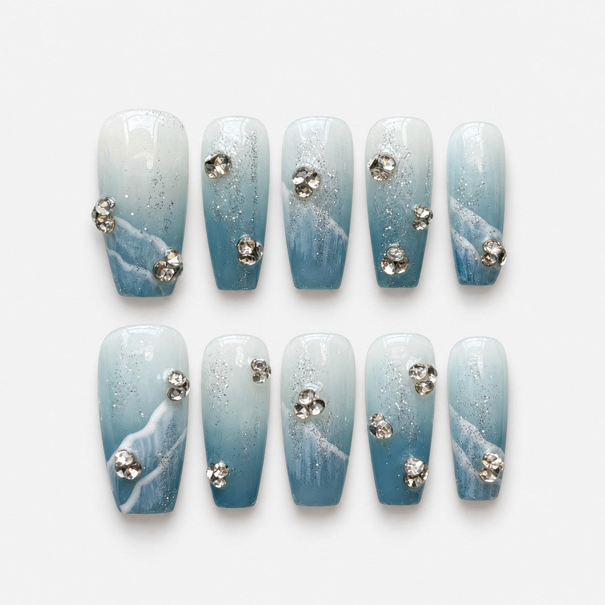 catalog: Medium coffin press-on nails in blue to white gradient with silver glitter, sculpted white waves and clear rhinestone clusters.