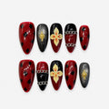 catalog: Medium almond press-on nails in dark wine red and black with painted cream orchids, black spots, a gold star charm and raised silver chains.